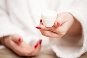 Woman holding in her hands cream for face skin care