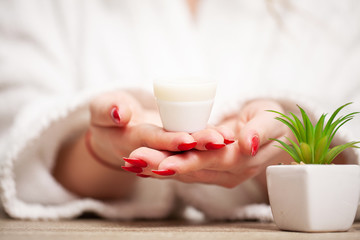 Woman holding in her hands cream for face skin care