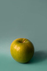 an apple on an aquamarine background
