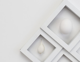 Two squares in the lower right on a white background. Close-up, top view. Egg and onion.