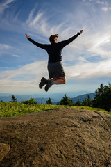 Woman Raises arms in Leap of Joy