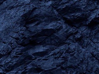Dark blue rock background. Toned mountain texture. Close-up. The combination of blue and volumetric stone texture. 3D effect.