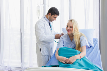 Obraz na płótnie Canvas Caucasian female patient in bed and doctor use stethoscope analyze symptom sick at hospital