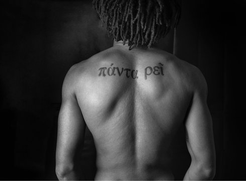 Rear View Of Shirtless Man With Tattoo On Back