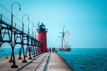 Tall ship sailing past a lighthouse on a summer day in South Haven