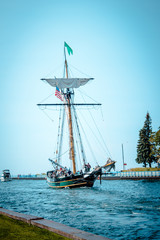 Tall ship setting sail from a harbor