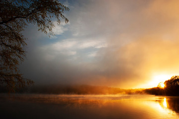 Fototapeta na wymiar Incredible sunset with mist rising from pond