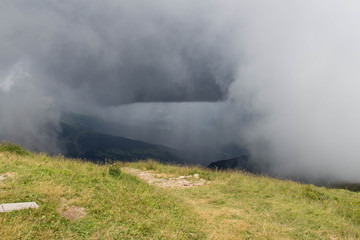 Thick rainy clouds above mountains lanscape in summer time.