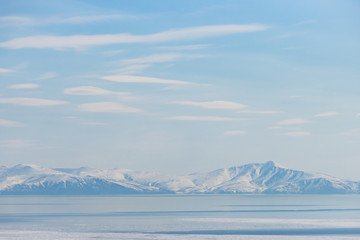 Landscape with sea bay, mountains and clouds in the sky. Gertner Bay, Sea of ​​Okhotsk. Magadan Region, Siberia, Far East of Russia. Great for background.