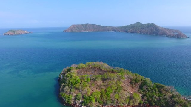 Hover Aerial View of Islands Adjacent to Bona Island Tip with Sparse Foliage, Rocky Shoreline and Bluw Sky
