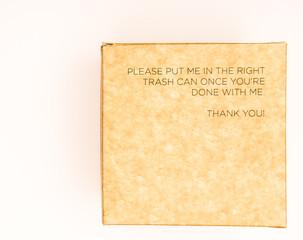 Brown box with the  text " Please put me in the right thrash can once you're done with me. Thank you!" 