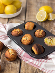Shaped Lemon muffins on an old vintage wooden table.