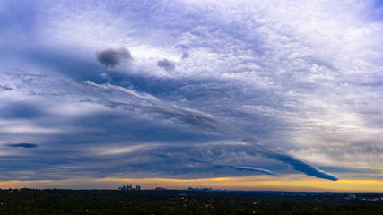 Panorama of dramatic colorful sky, cloud patterns and storm front over Sydney CBD and suburbs at sunset