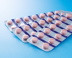 Pink pills placed on blue background