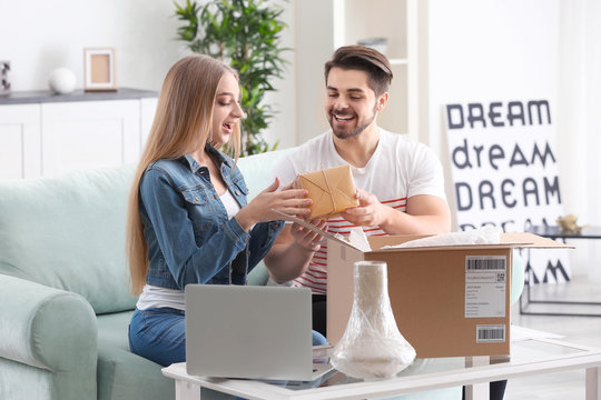 Young couple unpacking parcel at home