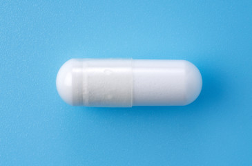 White capsules placed on blue background