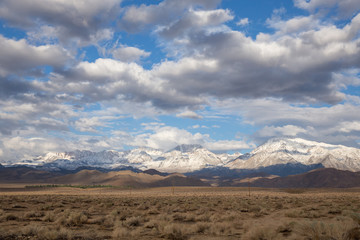 sunny morning with snowy mountain peaks and clouds 
