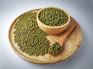 Green beans seed in a wooden tray, wooden spoon, wooden cup on Soft lights background