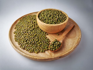 Green beans seed in a wooden tray, wooden spoon, wooden cup on Soft lights background