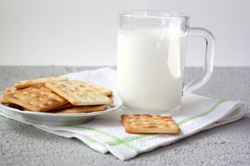 Biscuits and a cup of kefir on a gray background. Simple healthy food concept. Selective focus.
