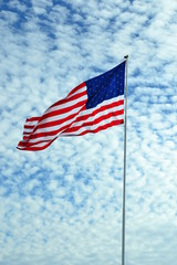American flag flying in wind, beautiful clouds pattern background.