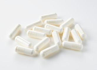 Fototapeta na wymiar White capsules placed on a white background