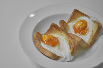Fried eggs, traditional rustic breakfast, fried eggs, sausage for breakfast on a wooden table background.