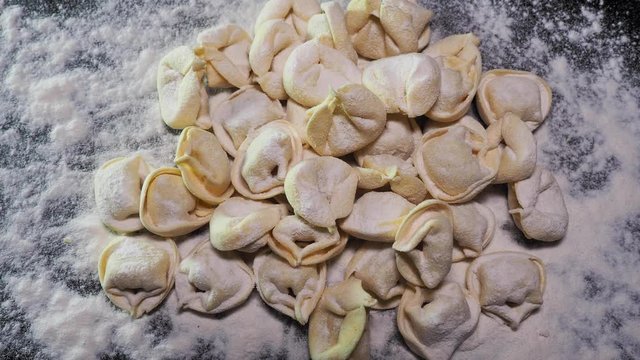 Delicious tortellini a ring-shaped pasta from Italy. Traditionally they are stuffed with a mix of meat, parmigiano reggiano cheese, egg and nutmeg. Black background