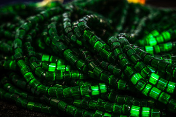 
round faceted beads with a matte and glossy finish in a low key and bokeh in the background