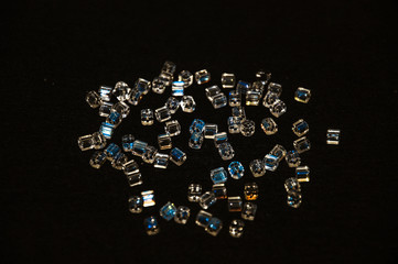 
blue square beads on a black background in low key