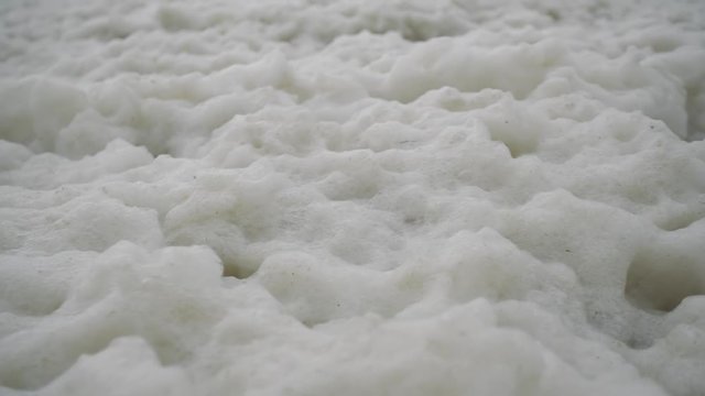 Closeup of a lot of sea foam in a storm on the seashore.