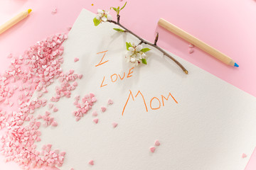 Children's greeting card for mom with mom's day on a pink background with confetti hearts and flowers.