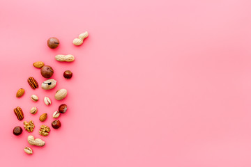 Nuts background - healthy snacks concept - on pink table top-down frame copy space
