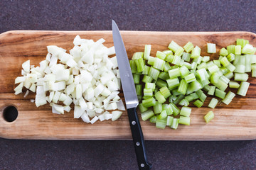 plant-based food, chopped onions and celeri on cutting board with knife