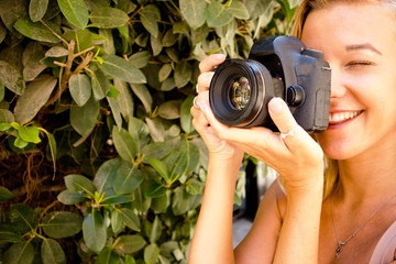 young beautiful girl standing in the park,smiling in the city of Valletta in Malta with a photo camera, traveling and taking photos