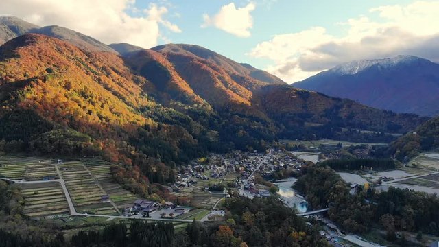Dolly in shooting by Drone shot of Aerial view over historical village Shirakawa-go village in the autumn during sunset. Shirakawa-go is one of Japan's UNESCO World Heritage Sites. 