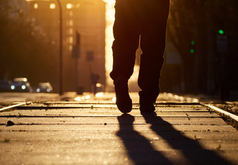 Man on the rails at sunset.