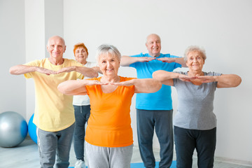 Fototapeta premium Elderly people exercising in gym