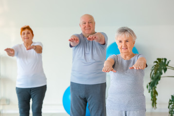 Elderly people exercising in gym