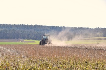 Bauer pflügt mit Traktor ein Feld in großer Hitze © Antje