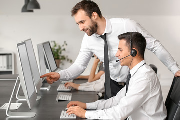Professional technical support agent teaching young people in office