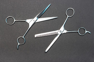 Hairdressing and filler scissors on black background, view from above