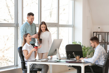 Colleagues drinking coffee during work in office