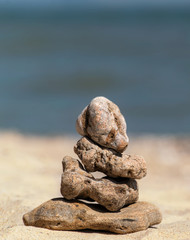 Fototapeta na wymiar Zen concept. Object made of stone on the beach. Stone pyramid for meditation. Harmony and Meditation. Zen stones.