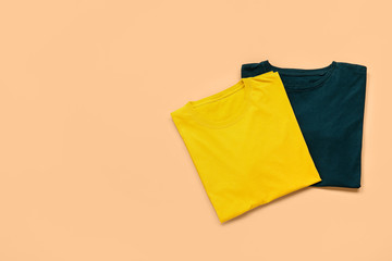 Stylish t-shirts on color background