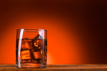 A glass of whiskey or cognac and ice cubes.
