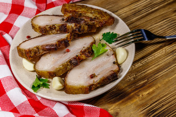 Baked pork belly in a plate on wooden table
