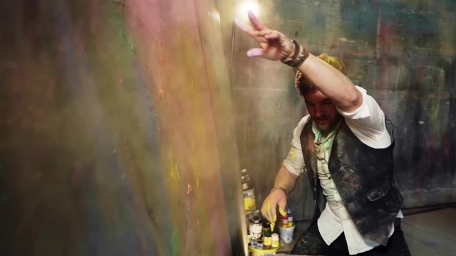 Focused, impressive artist paints a painting with dry paints