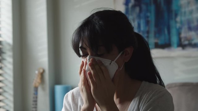 A young Latina woman puts on a coronavirus mask, closeup 4k.