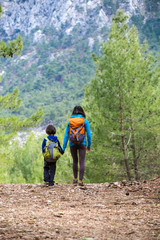A child with his mother go hiking.